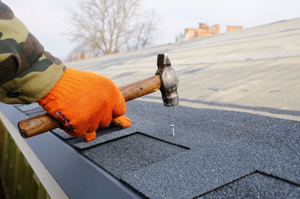 Builder Building Roof. Worker Hammer in Nails on the Roof. North Oaks, MN