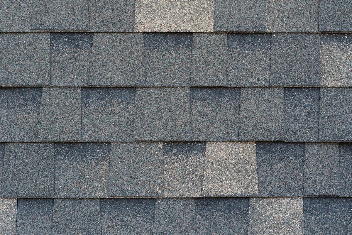Close-up texture of dark gray asphalt roofing shingles, North Oaks
