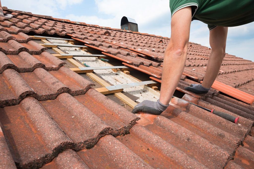 person repairing tile roof in North Oaks