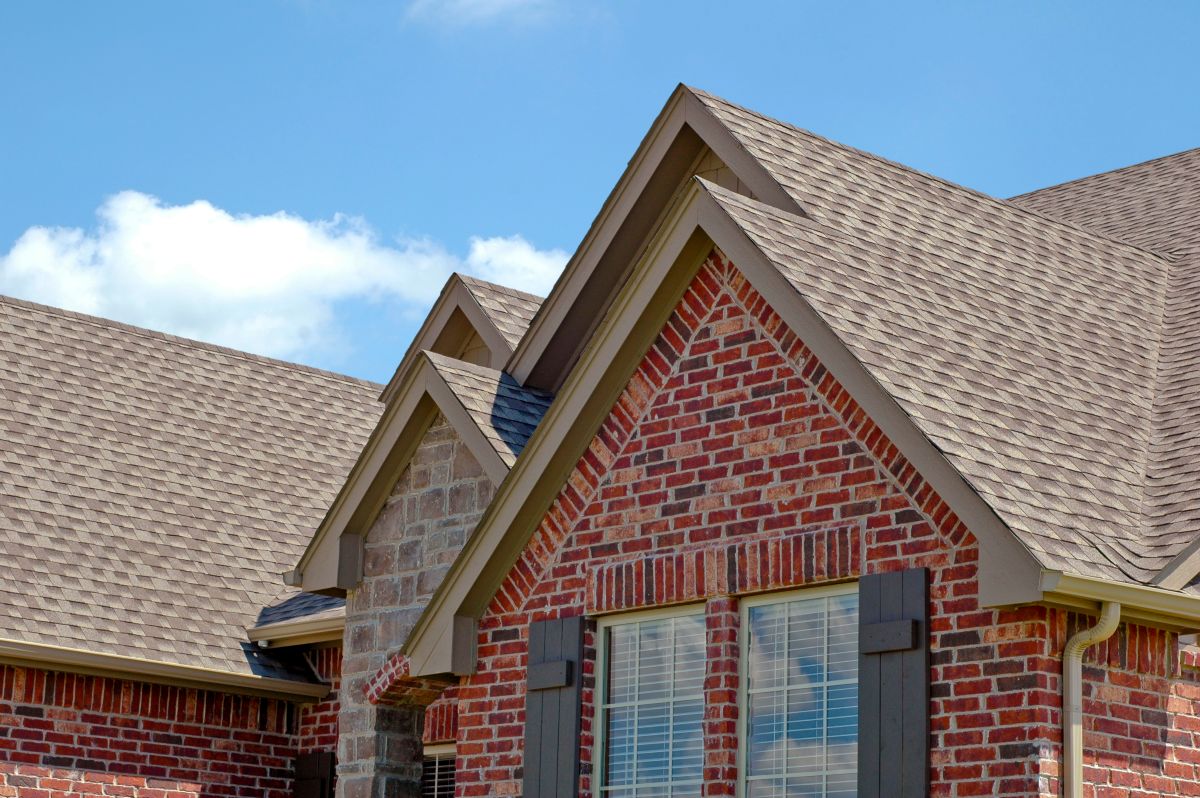 red brick house with grey shingles on the roof in North Oaks, Minnesota