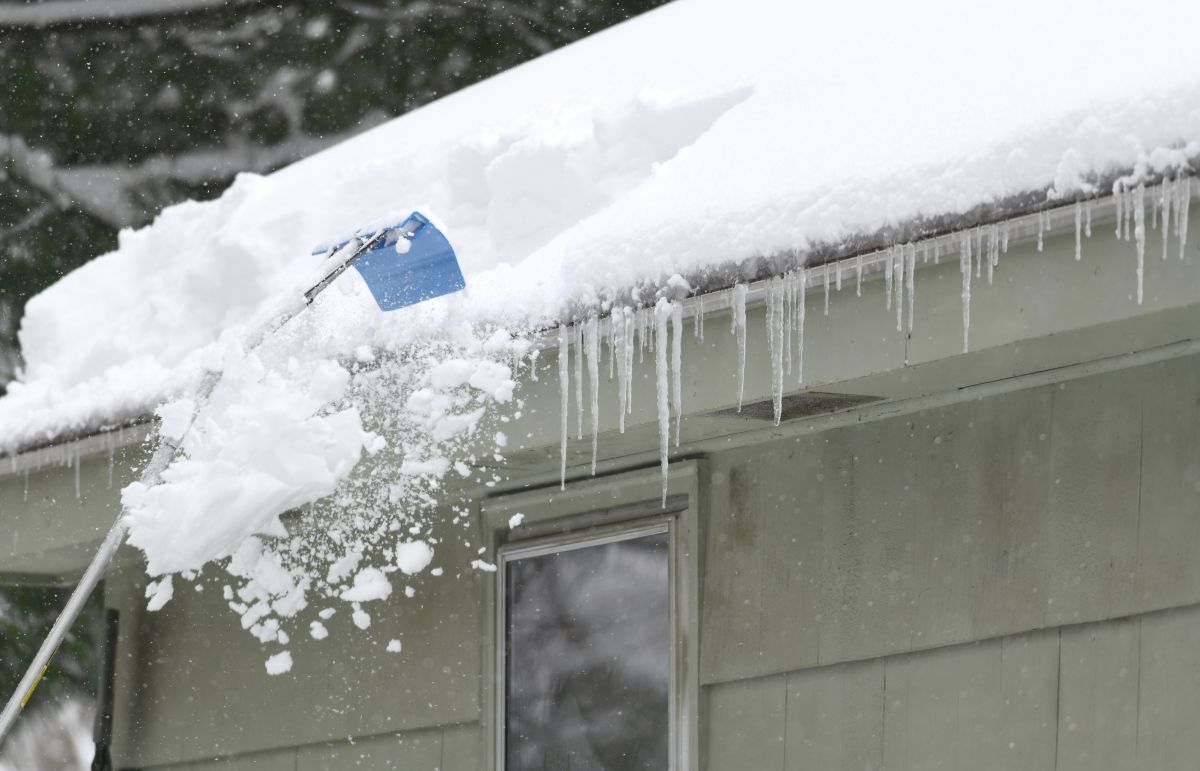 removing snow on the roof after snow storm in North Oaks, MN